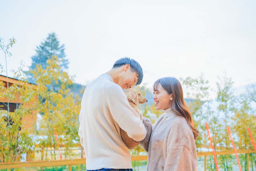 Couple smiling with their dog in between